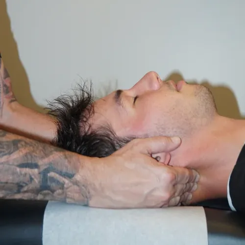 Best Chiropractor Near Me in Grand Blanc, MI, Dr. Keith Denning Performing Chiropractic Neck Adjustment on Patient.